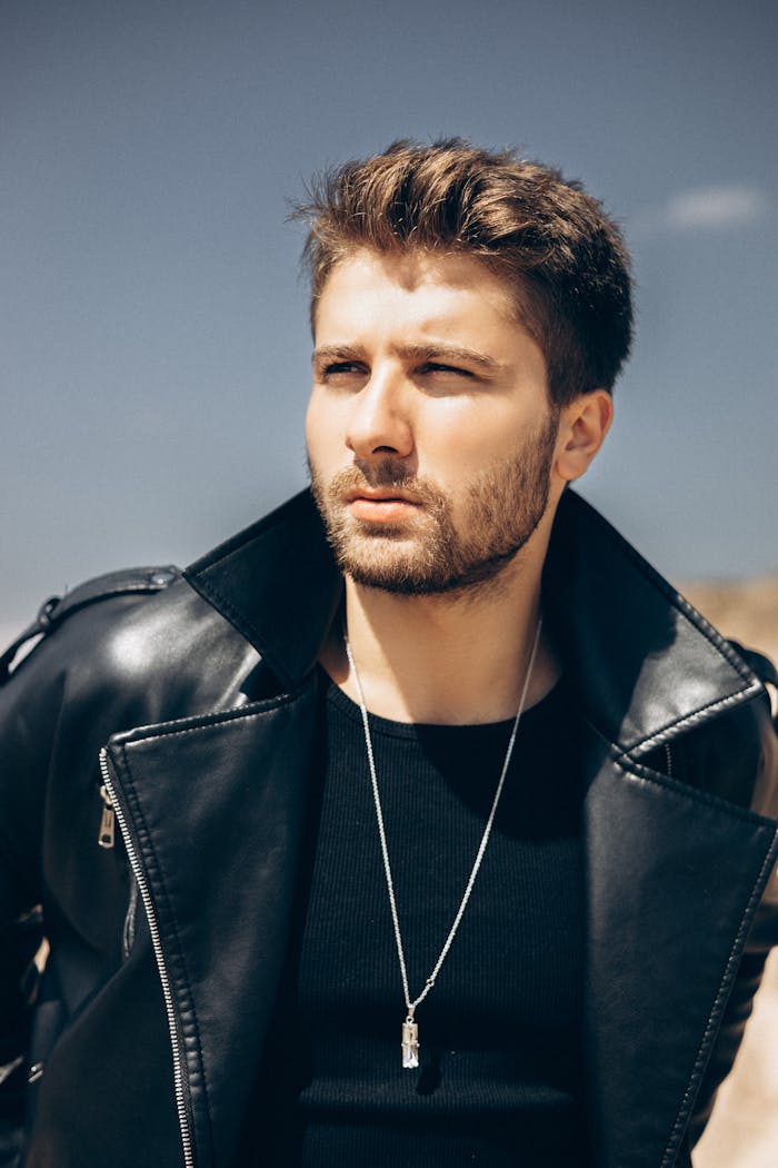 about-img Portrait of a stylish man in a black leather jacket and necklace, outdoors in Turkey.