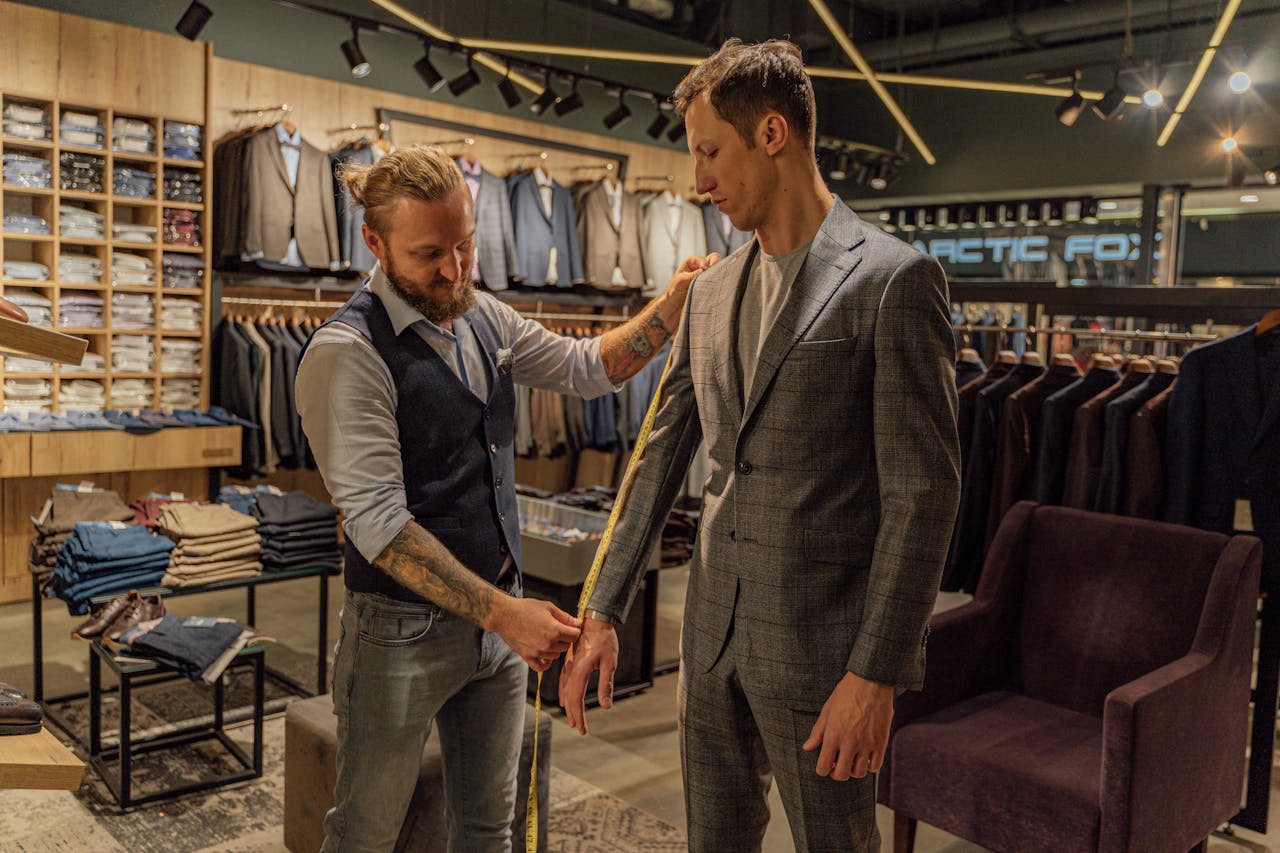 hero-gallery-01 Tailor measuring a customer in a suit store for a perfect fit.