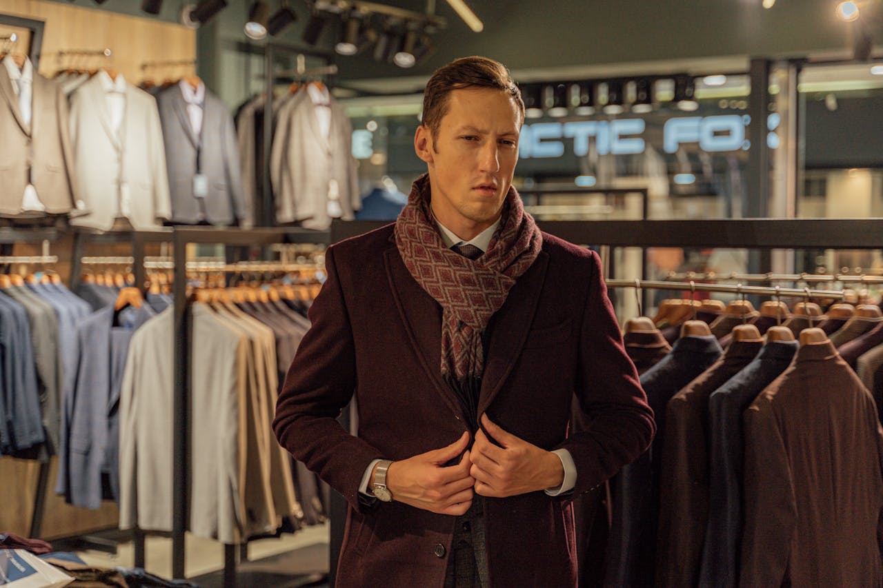 hero-gallery-03 A stylish man in a high-end menswear boutique choosing a coat.